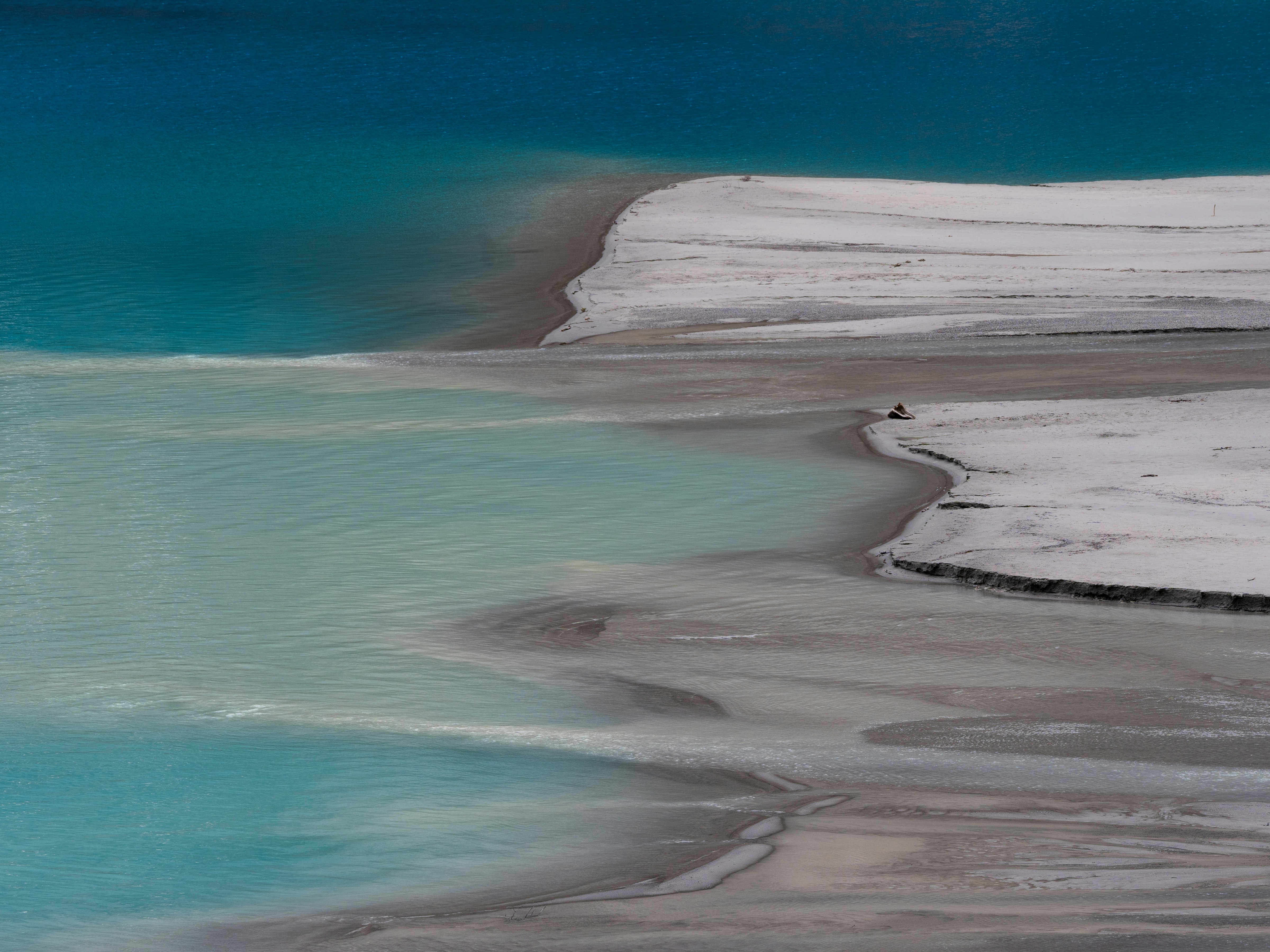 A body of water surrounded by snow covered mountains