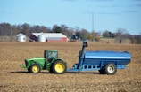 A tractor pulling a trailer behind it in a field