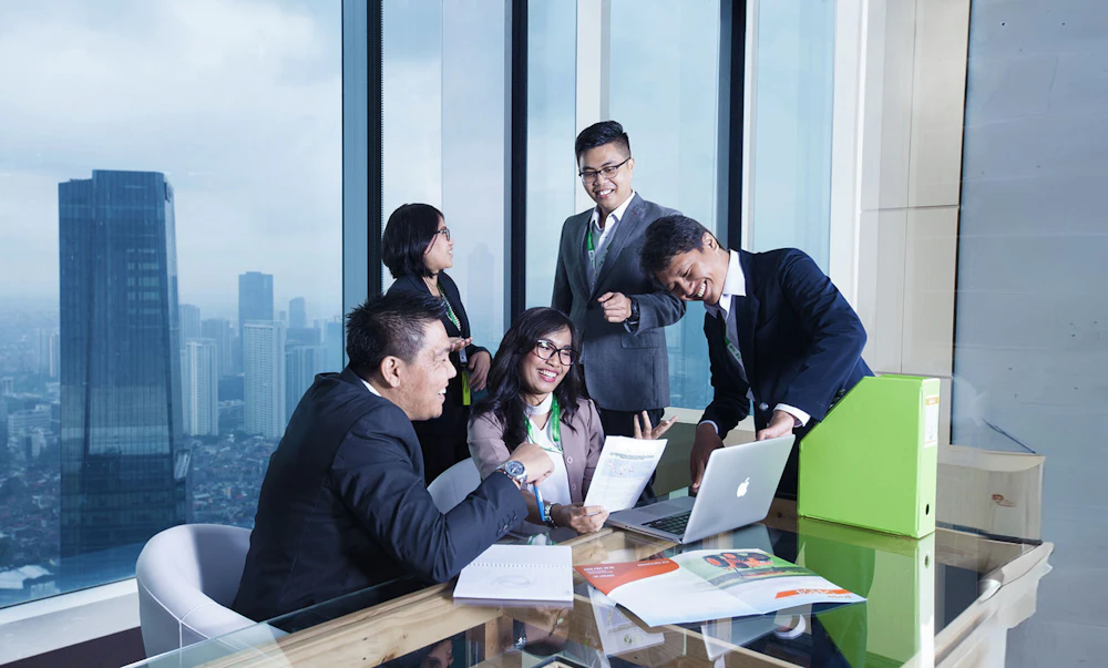 Recruitment staff reviewing candidate files around an office table – placeholder for real FINAS office photography