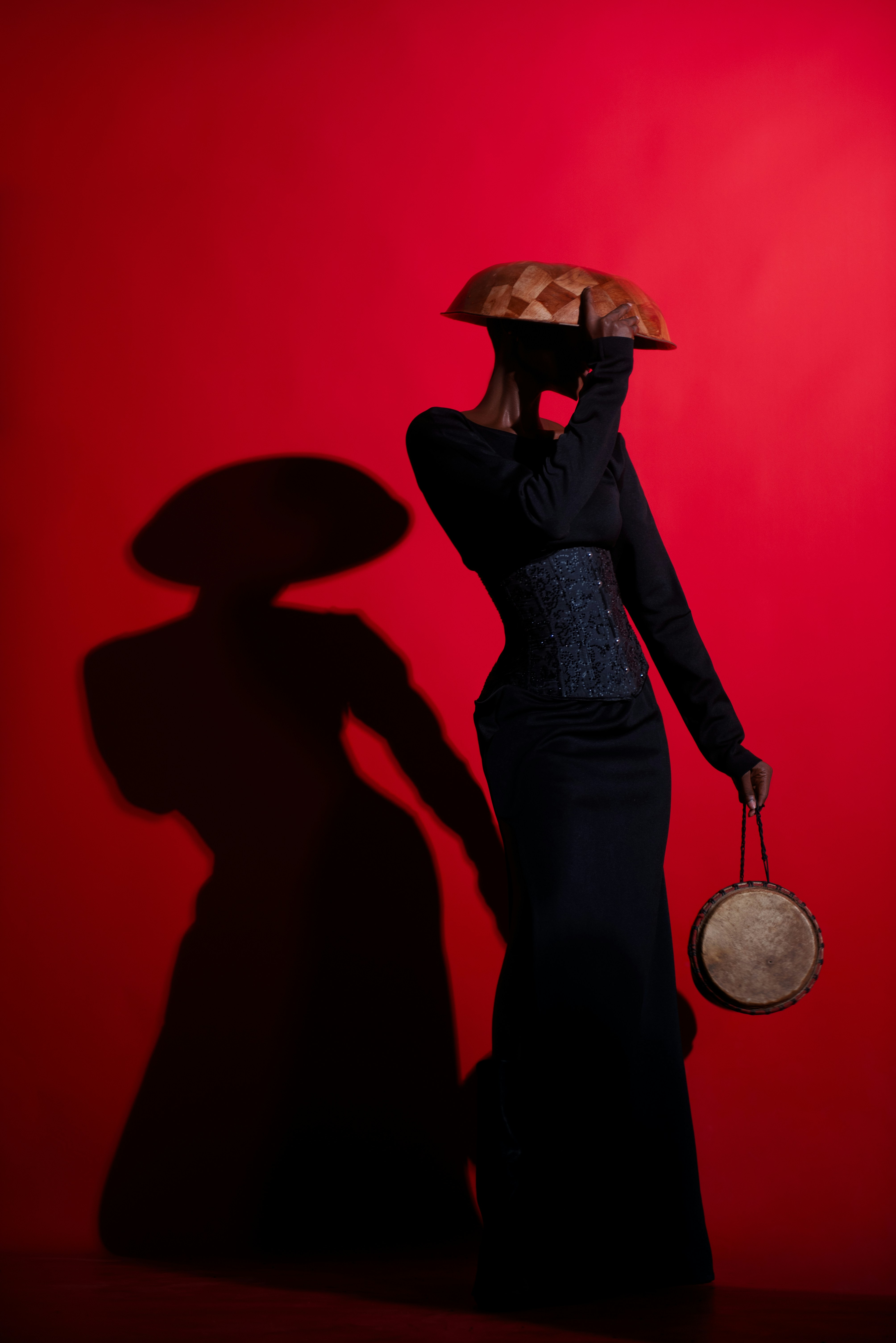A woman in a black dress and hat with a red background photo – Free ...