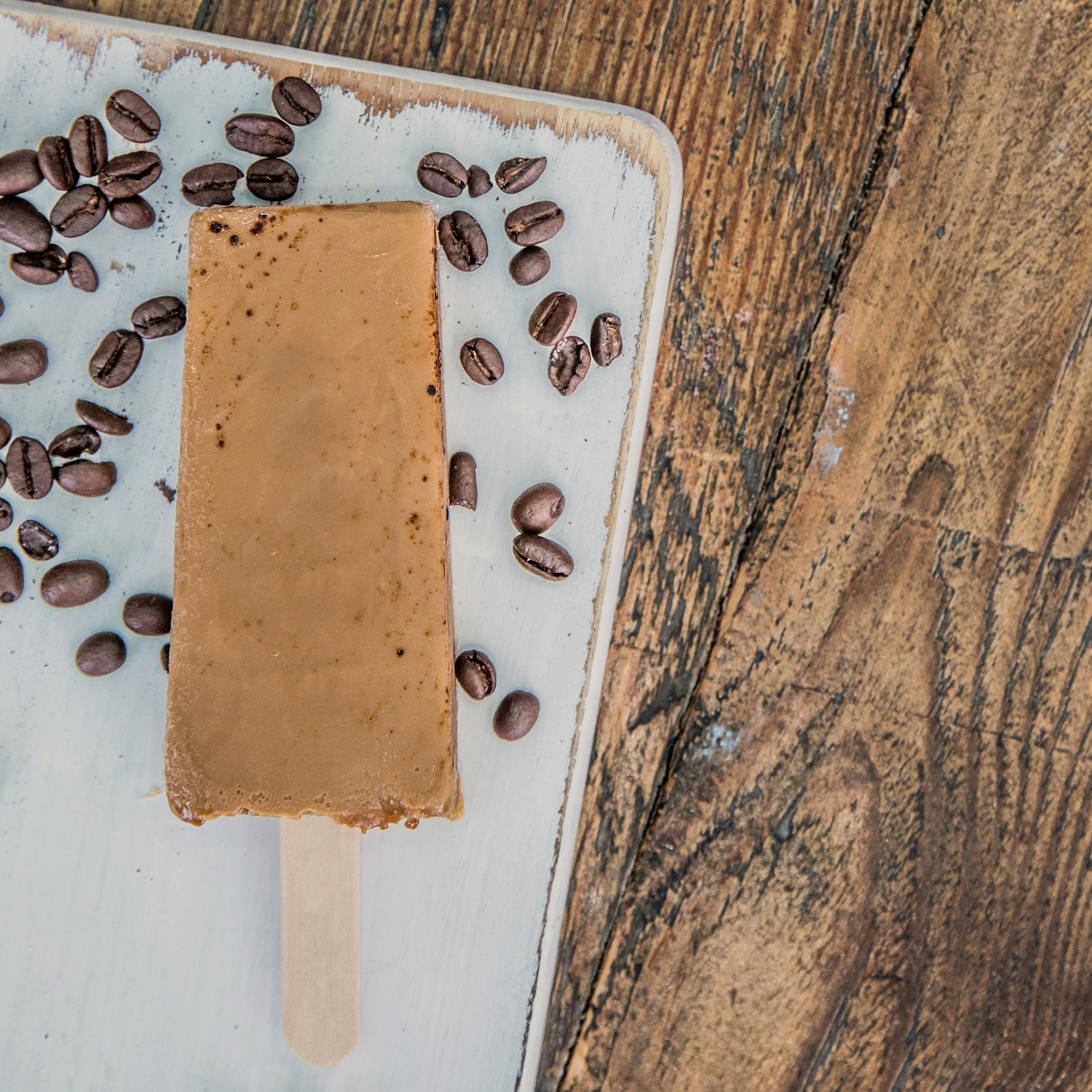 A popsicle with coffee beans on top of it