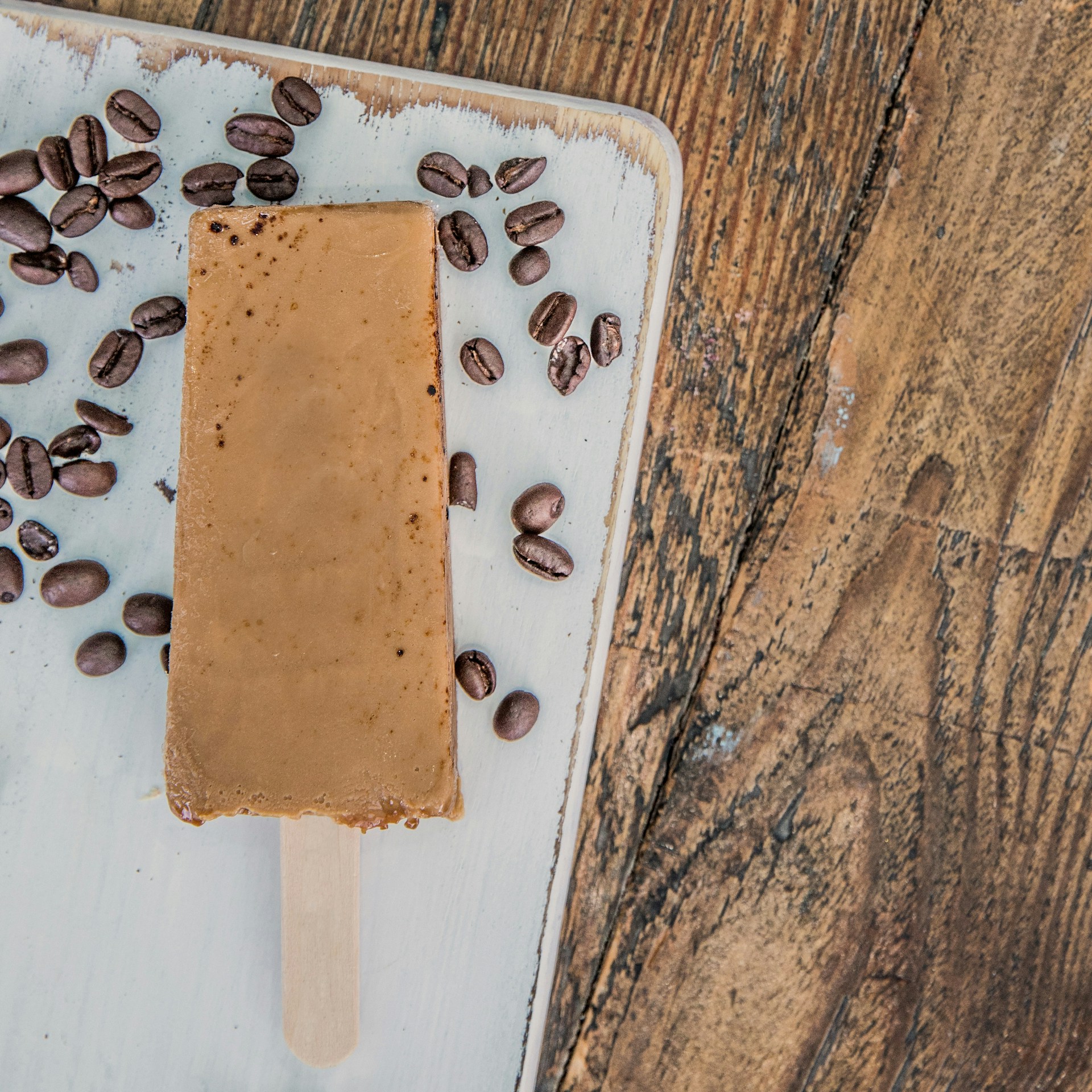 A popsicle with coffee beans on top of it
