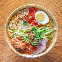 A bowl filled with noodles, meat and vegetables