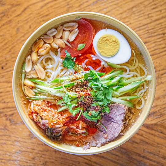 A bowl filled with noodles, meat and vegetables