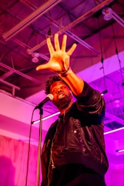 A man holding his hand up in front of a microphone