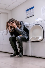 A woman sitting on top of a washing machine