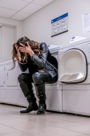 A woman sitting on top of a washing machine