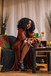A woman sitting on top of a couch next to a table