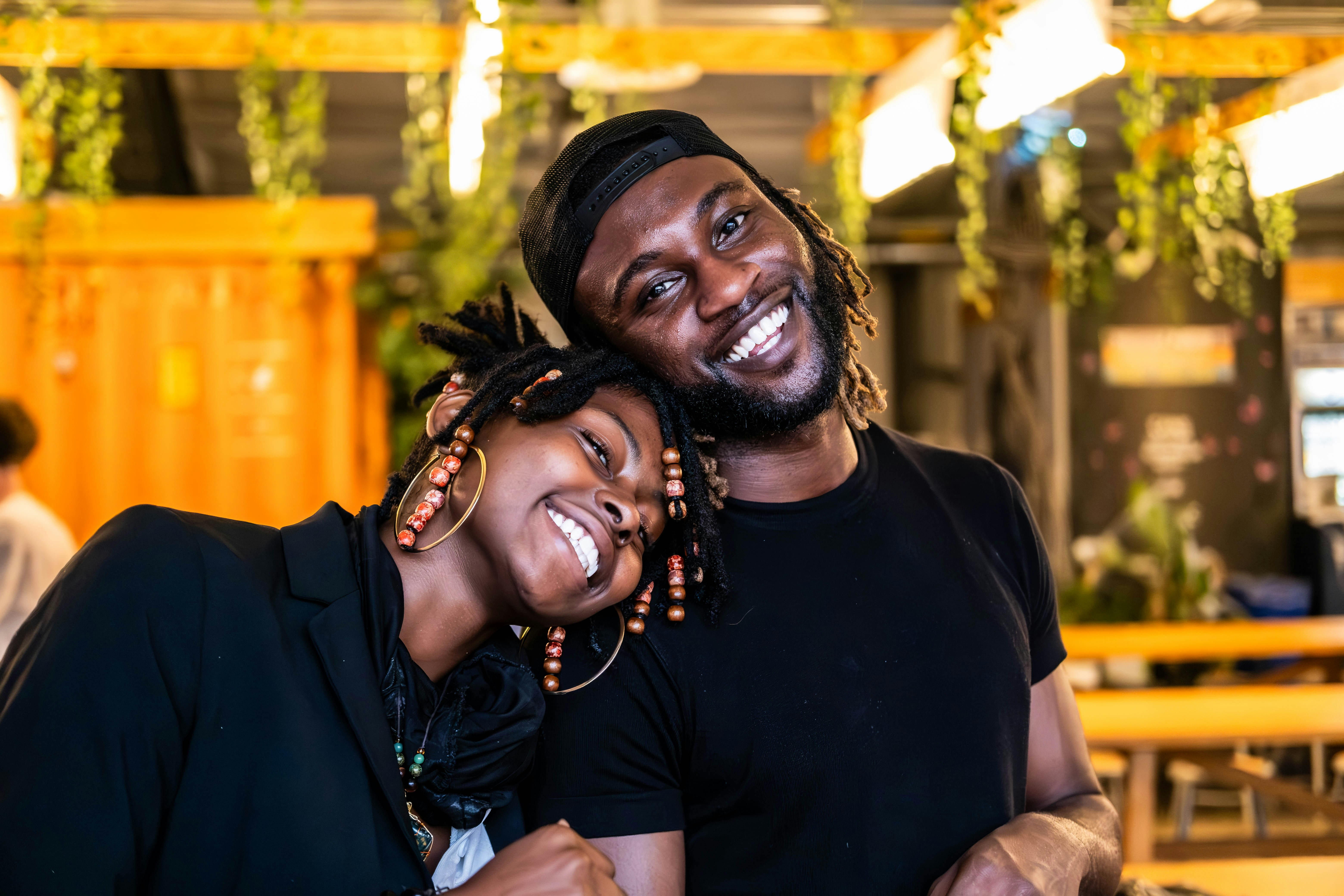 African American couple smiling together in bright living room, warm home lighting