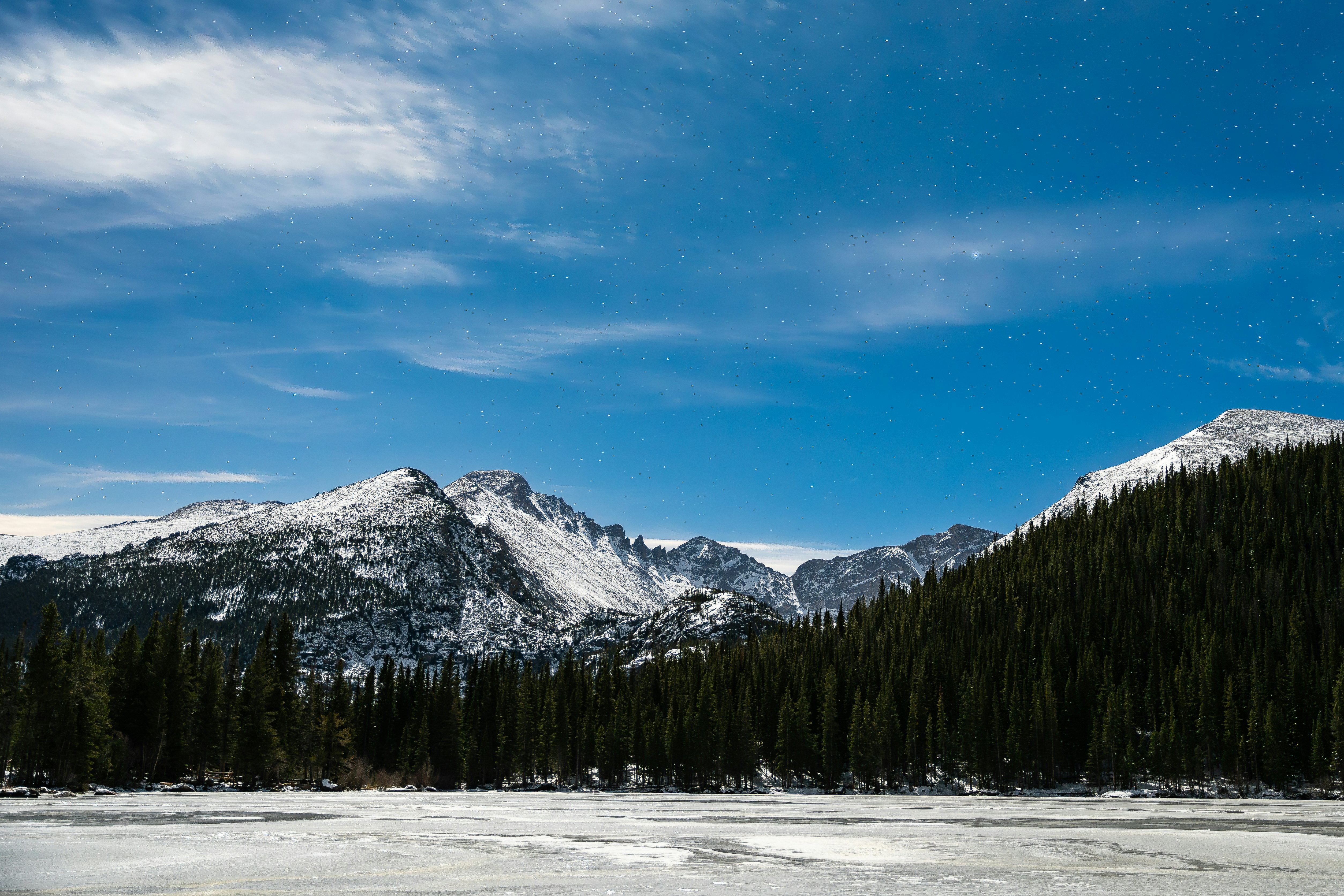 A snow covered field with mountains in the background
