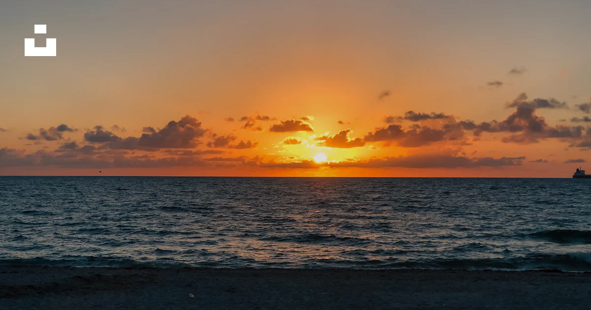 Ocean In The Distance A sunset over the ocean with a boat in the distance photo – Free ...
