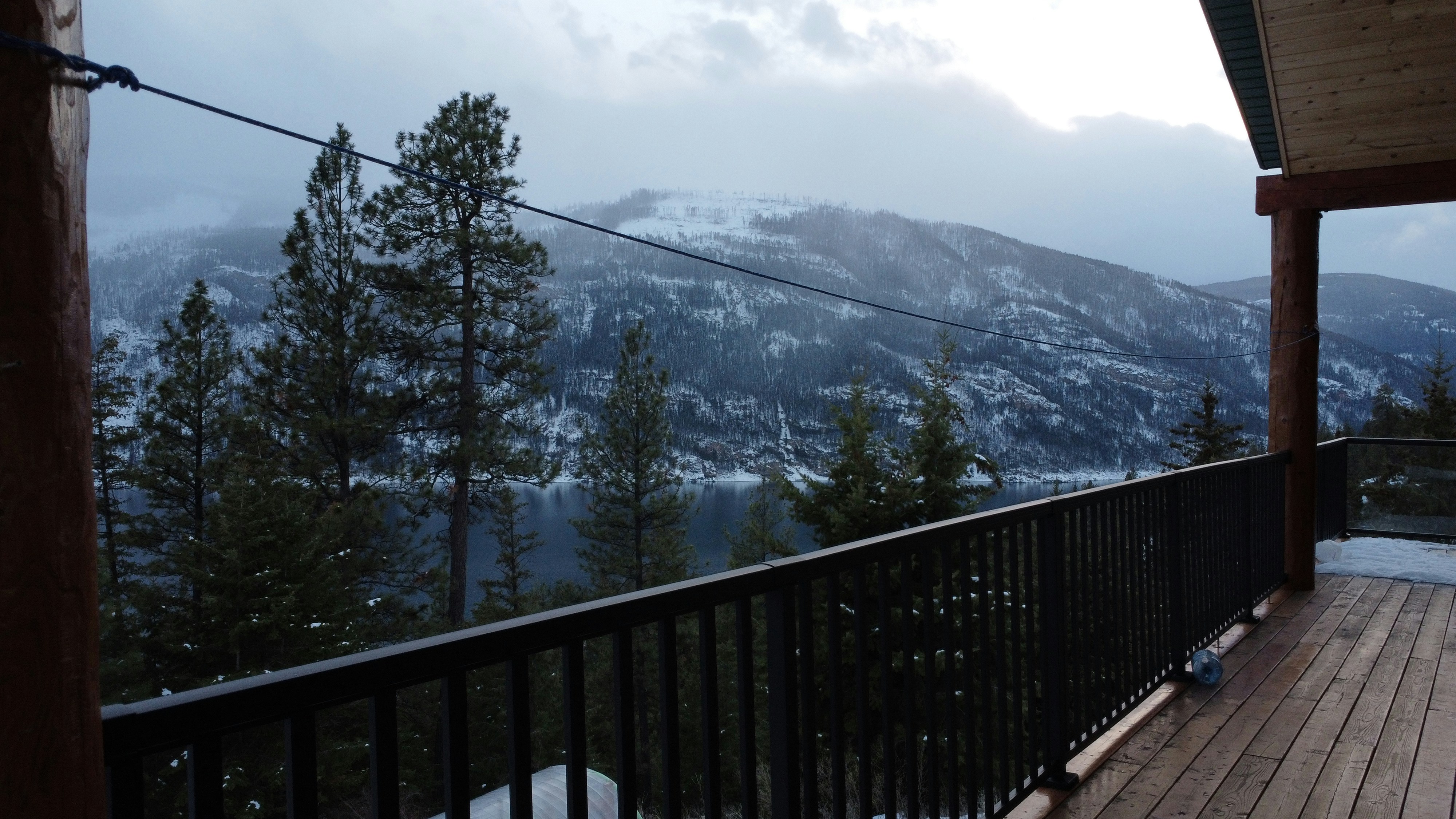 a beautifully designed brown composite deck with matte black aluminum railing overlooking the Wasatch mountains at sunset