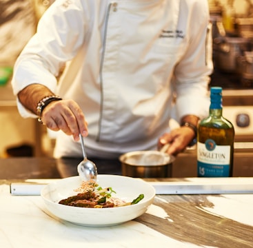A chef is preparing a dish in a kitchen
