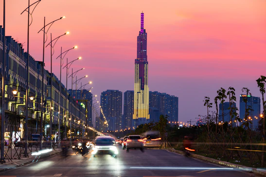 A car driving down a street next to tall buildings
