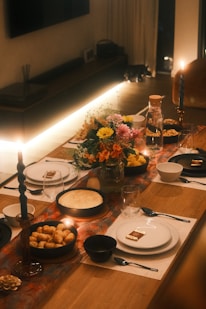 A long table with plates and candles on it