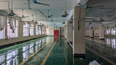 A large room with lots of windows and a ceiling fan