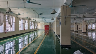 A large room with lots of windows and a ceiling fan
