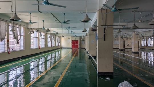 A large room with lots of windows and a ceiling fan