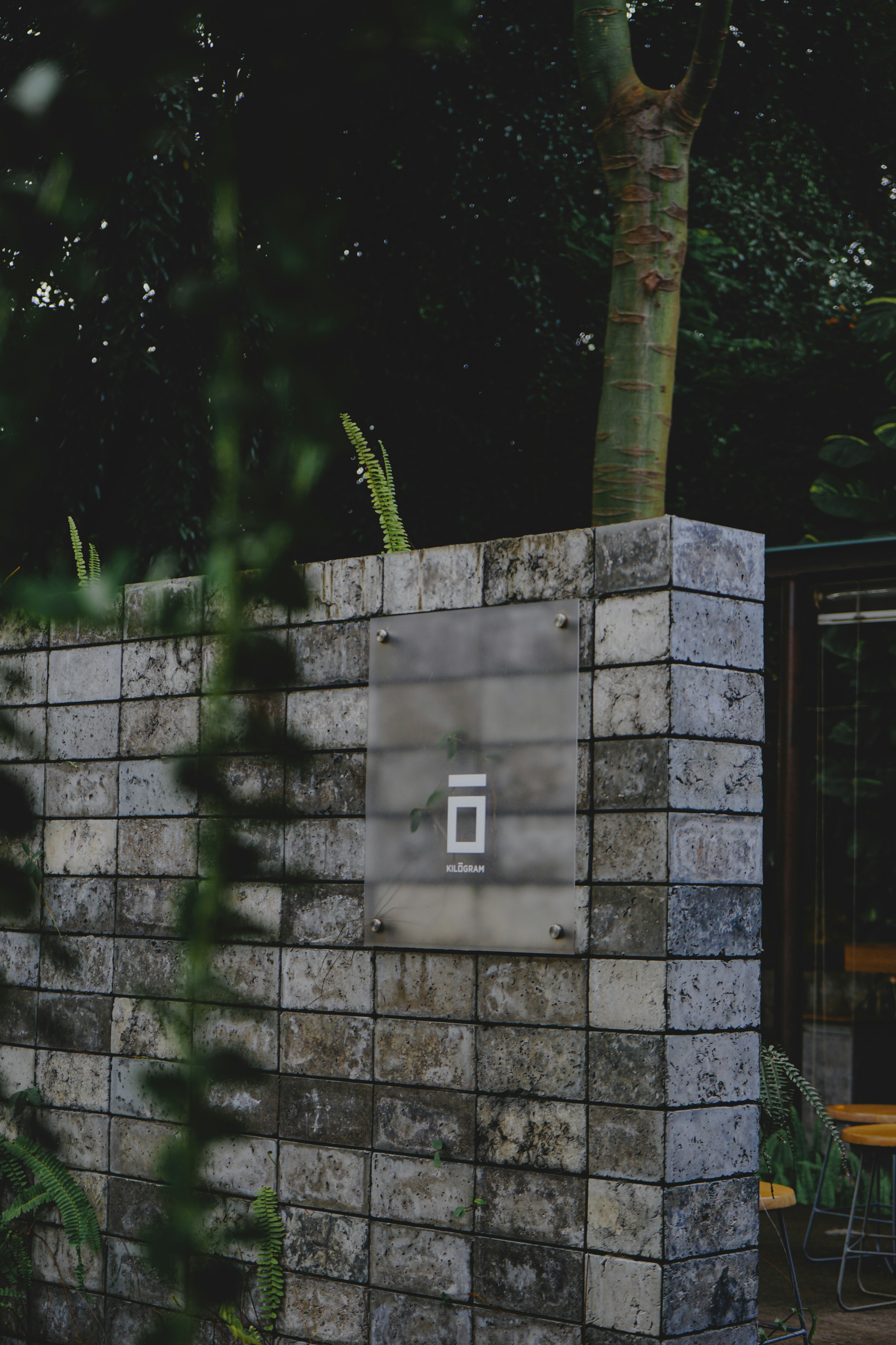 A brick wall in front of a table and chairs