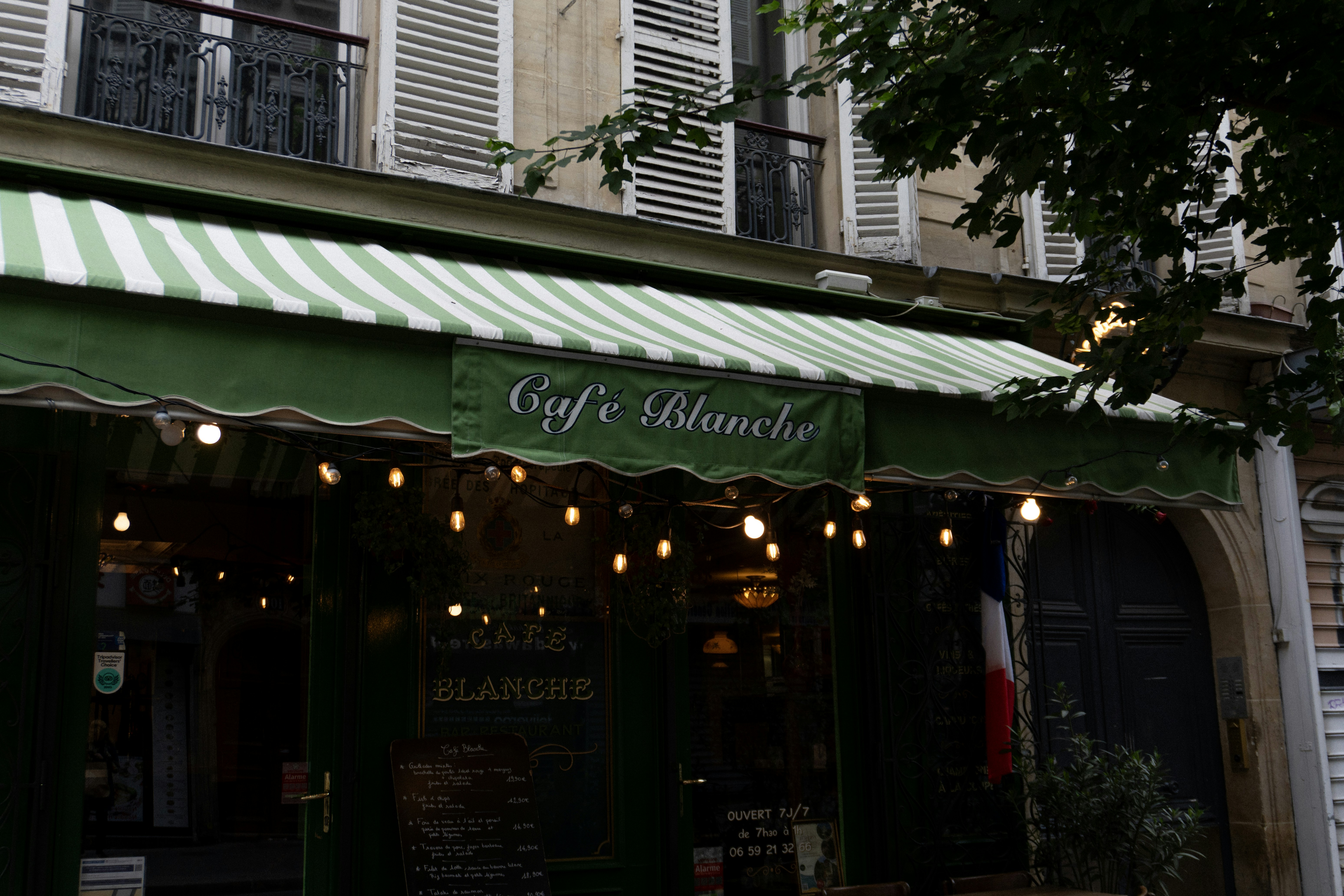 Un auvent vert et blanc sur la devanture d’un magasin