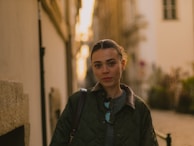 A woman walking down a street next to a building