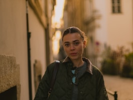 A woman walking down a street next to a building