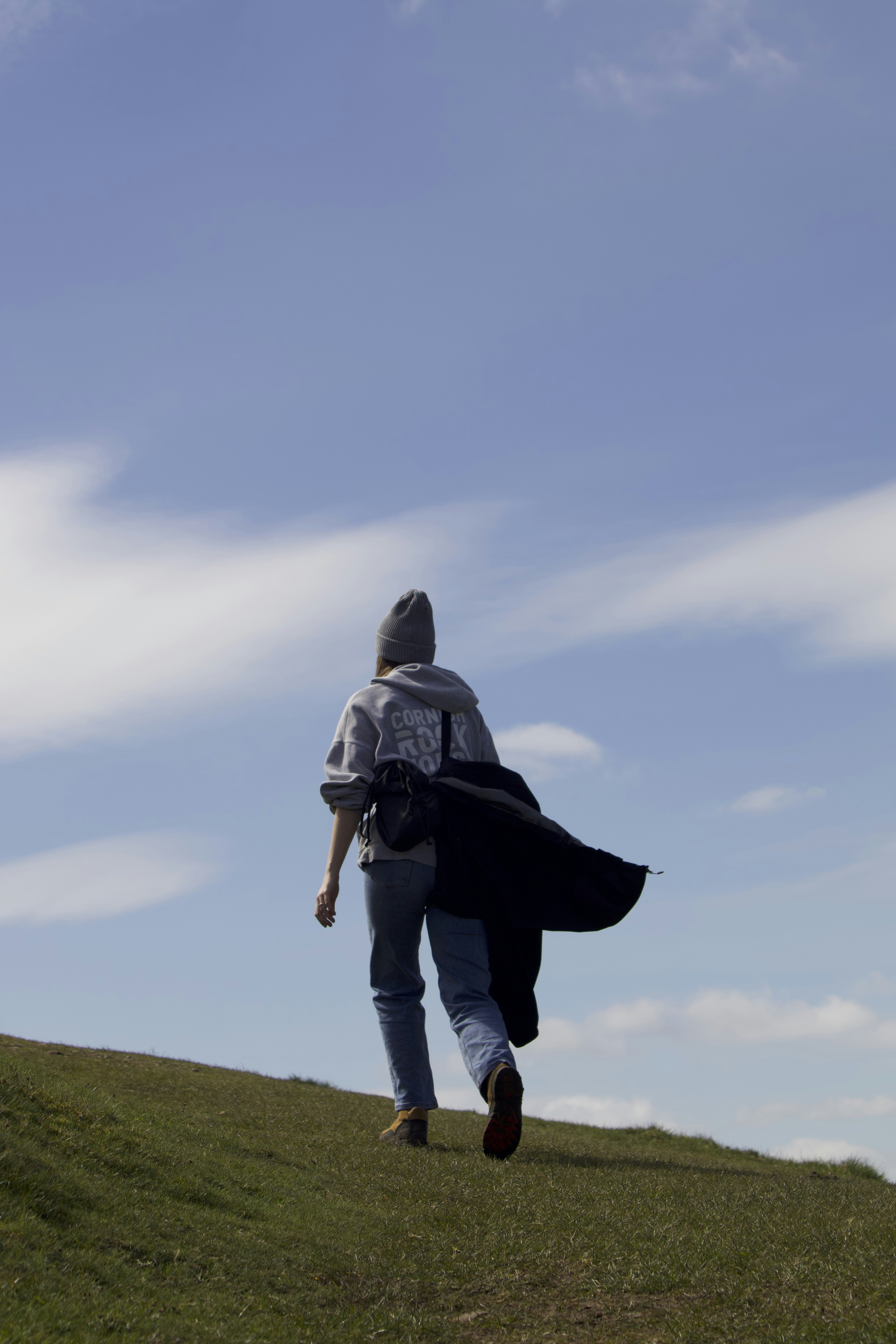 A person walking up a hill with a backpack