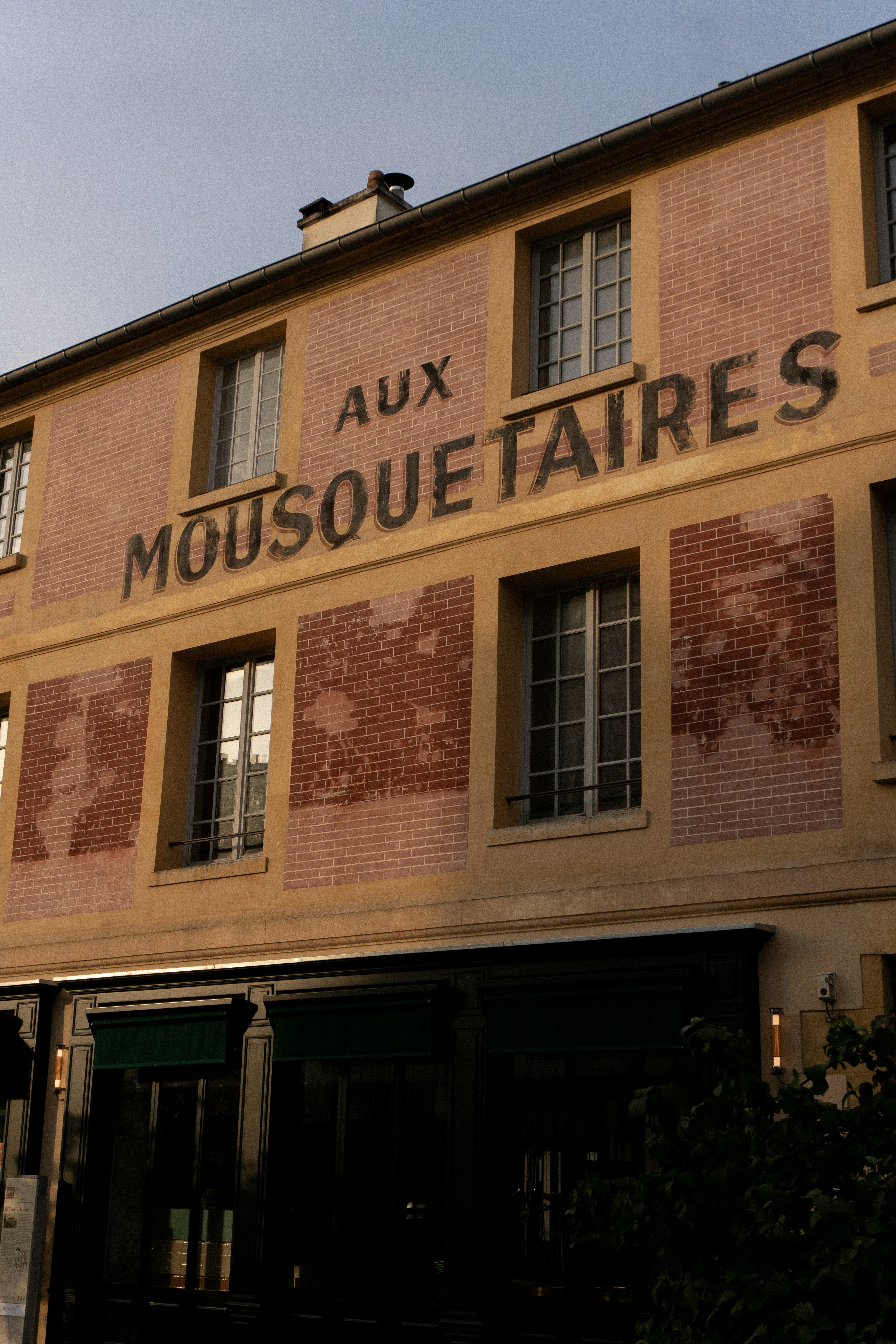 Un grand bâtiment en brique avec un panneau sur le côté