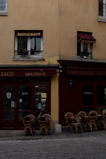 A row of tables and chairs outside of a restaurant