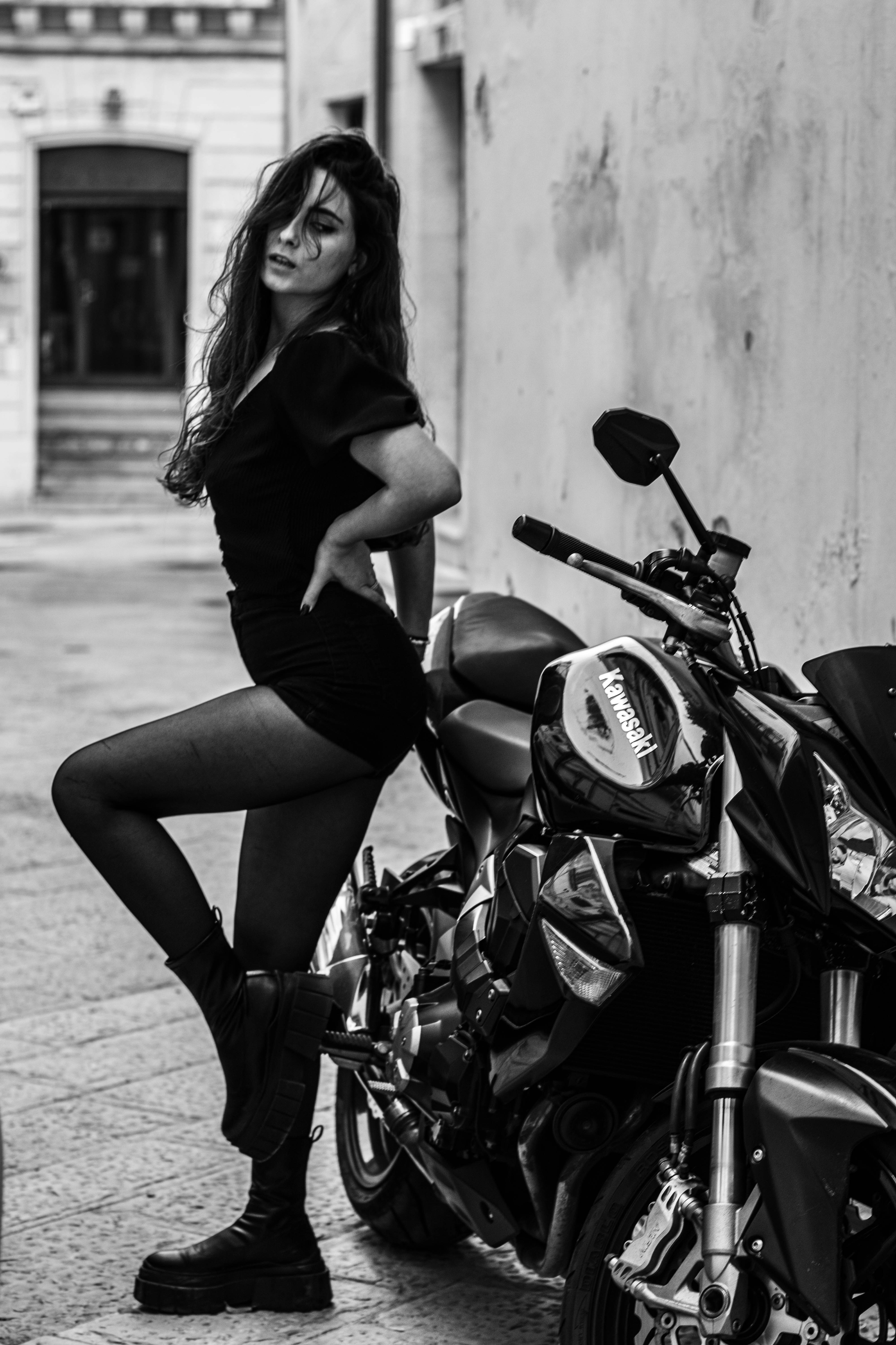 A woman posing next to a parked motorcycle photo – Free Background ...