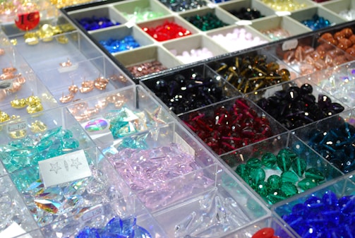 Many different colored beads are on display in bins