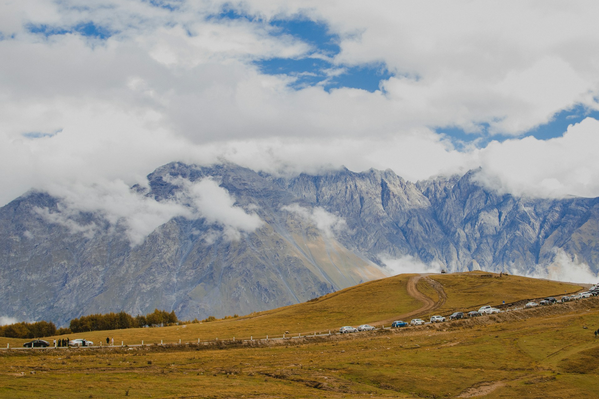 A grassy field with mountains in the background