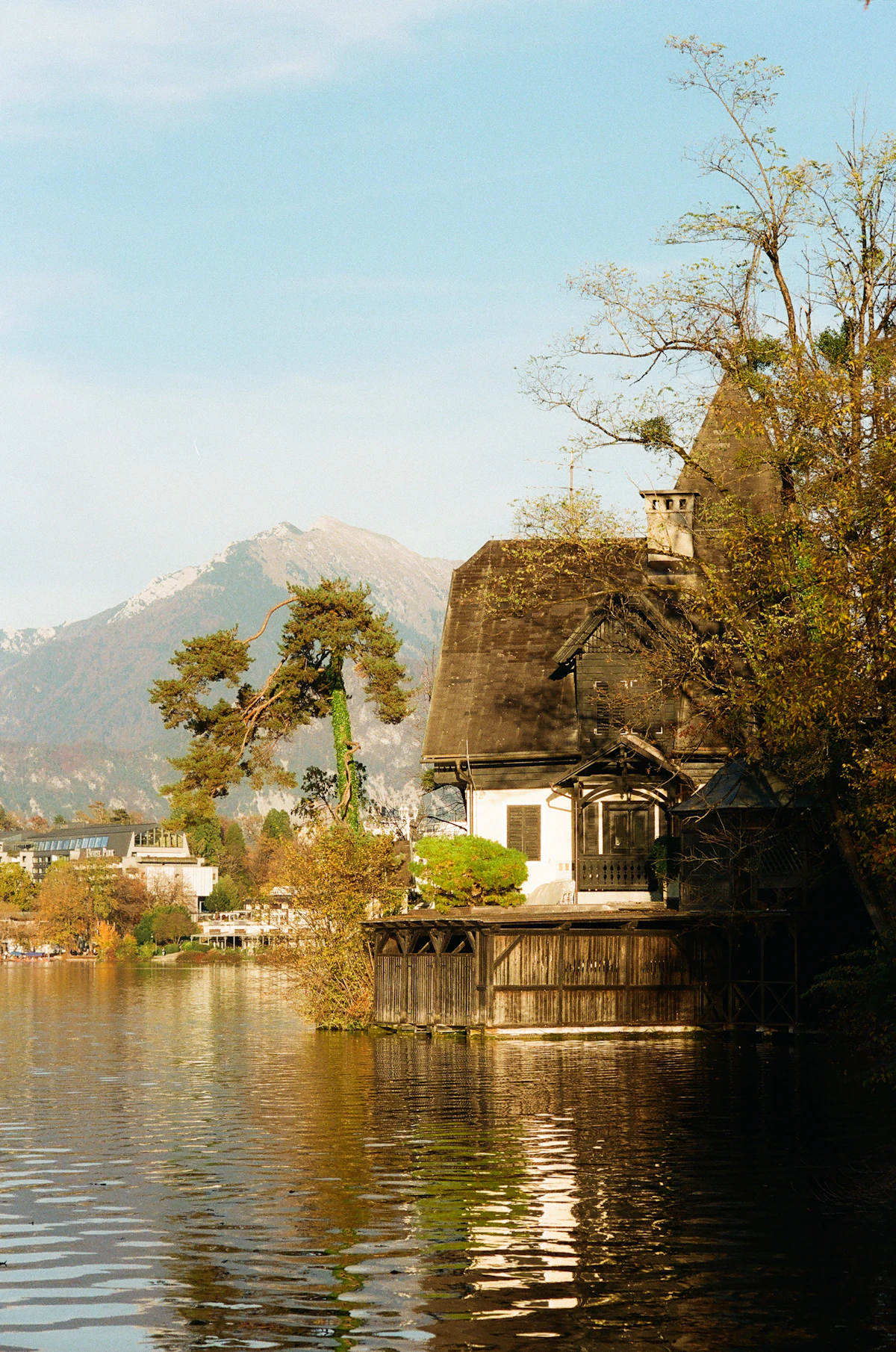 Lakeside wooden house beside Lake Bled with mountains in the background