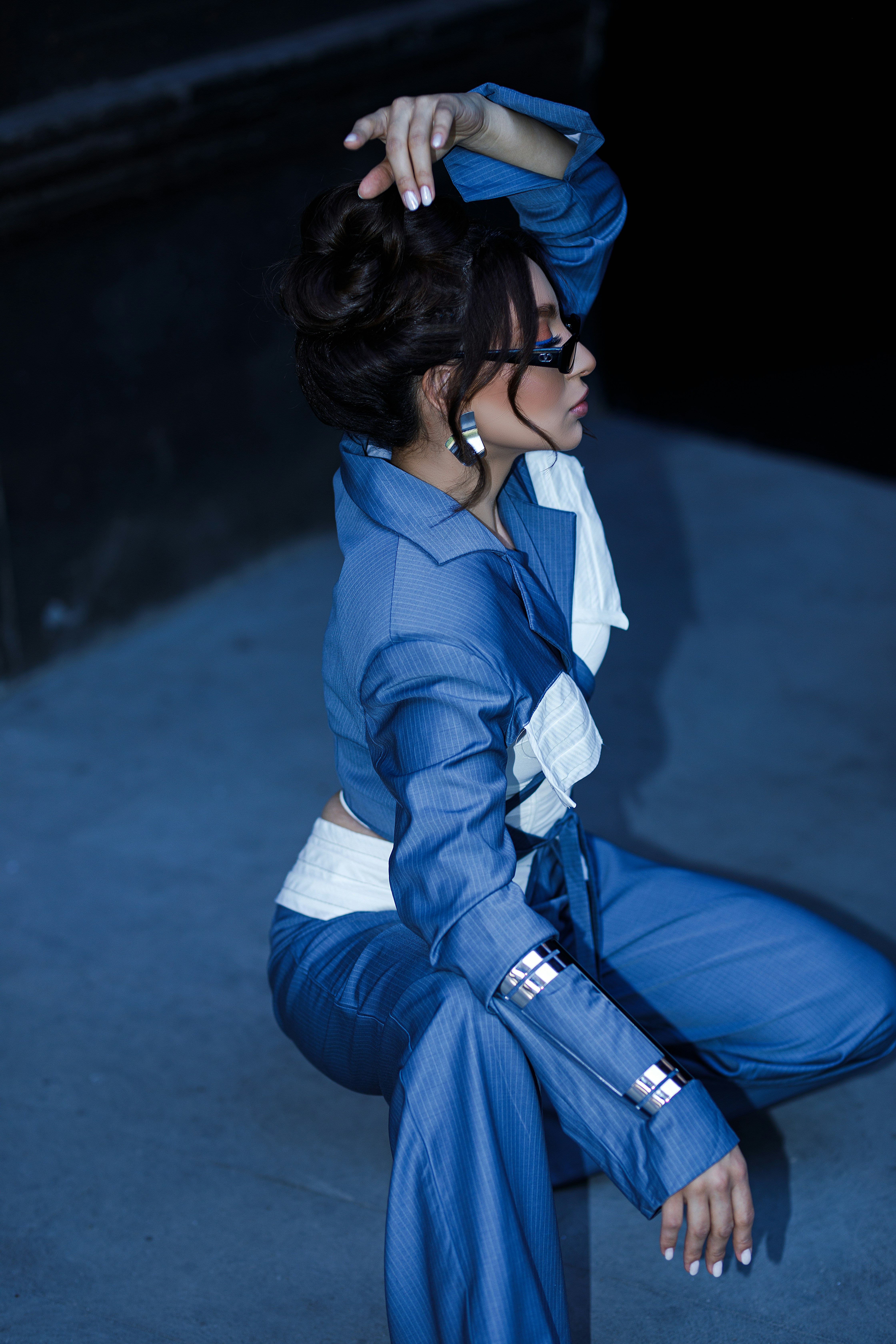 A woman sitting on the ground in a blue outfit