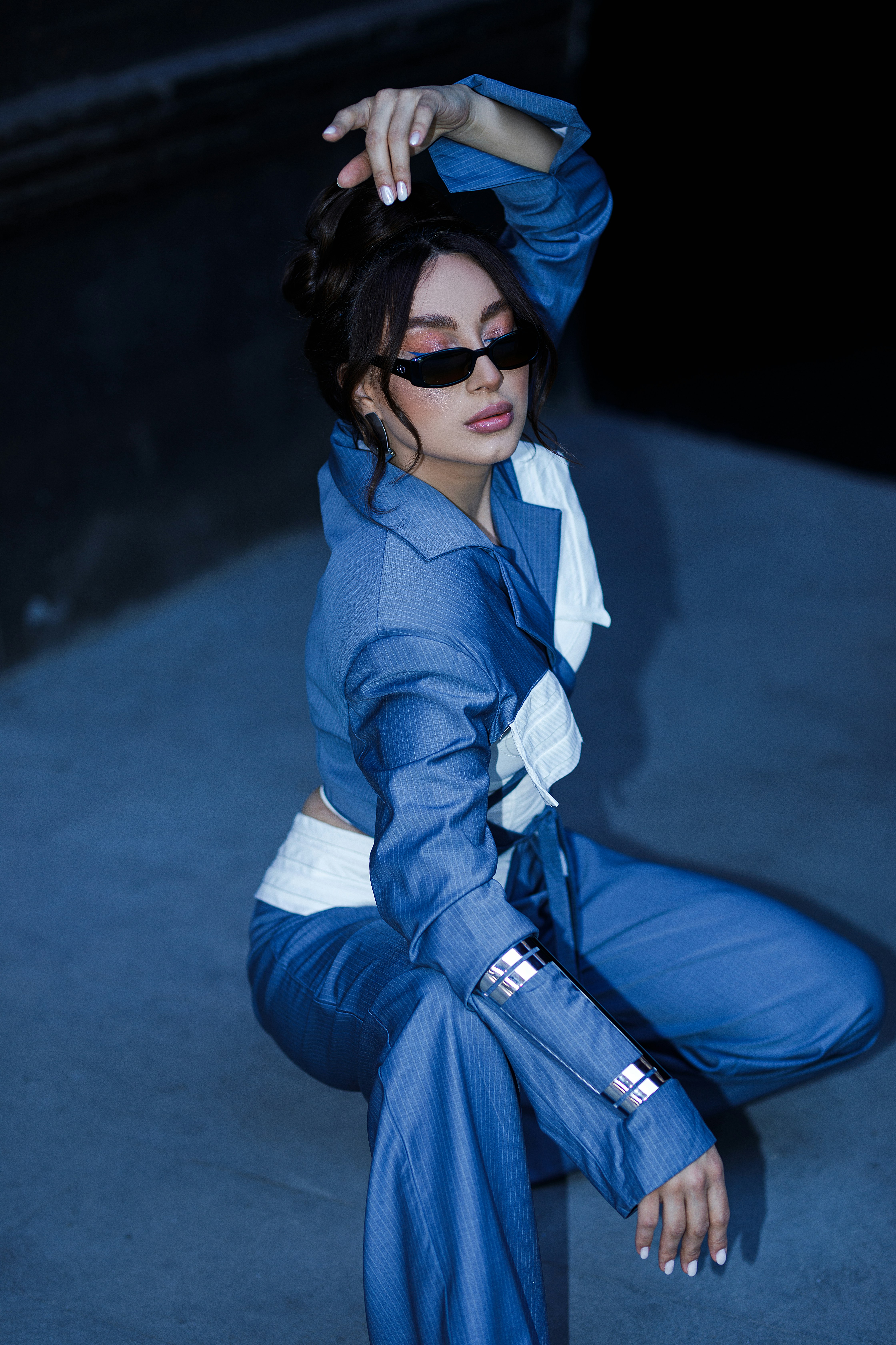 A woman sitting on the ground in a blue outfit