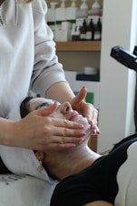 A woman getting a facial mask on her face