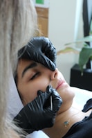 A woman getting her nose examined by a doctor