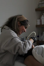 A woman in a hospital bed getting her foot examined