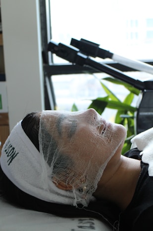 A woman with a sheet on her head laying on a table
