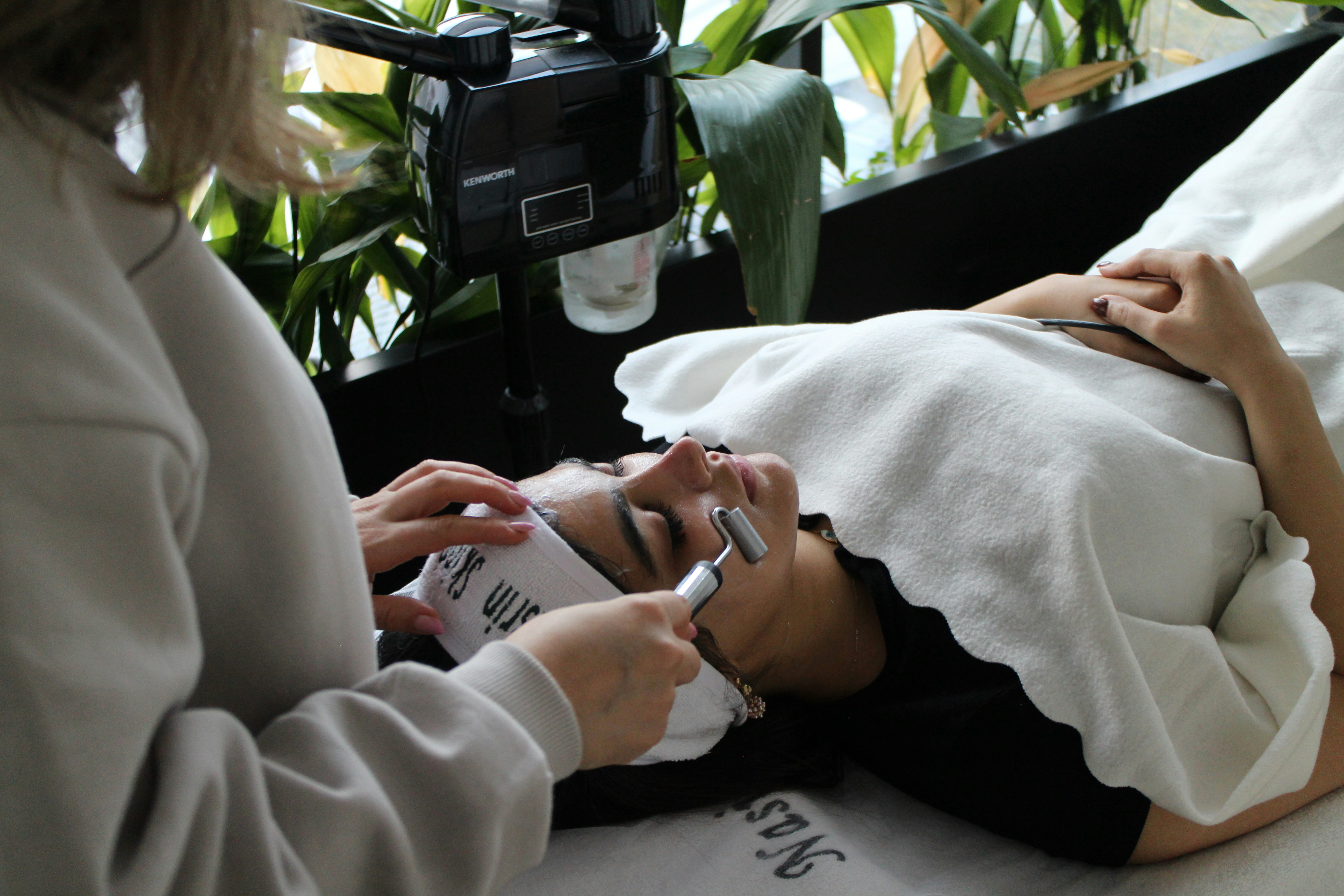 A woman laying on a bed while using a cell phone