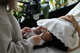 A woman laying on a bed while using a cell phone