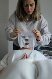 A woman holding a sheet of paper with a mask on it