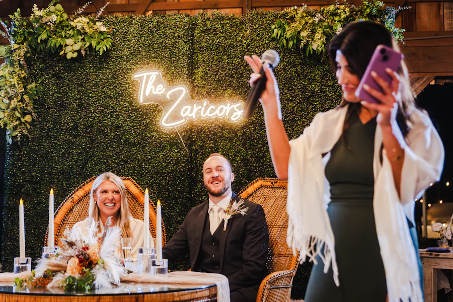 Wedding guest taking a photo with her phone at a reception