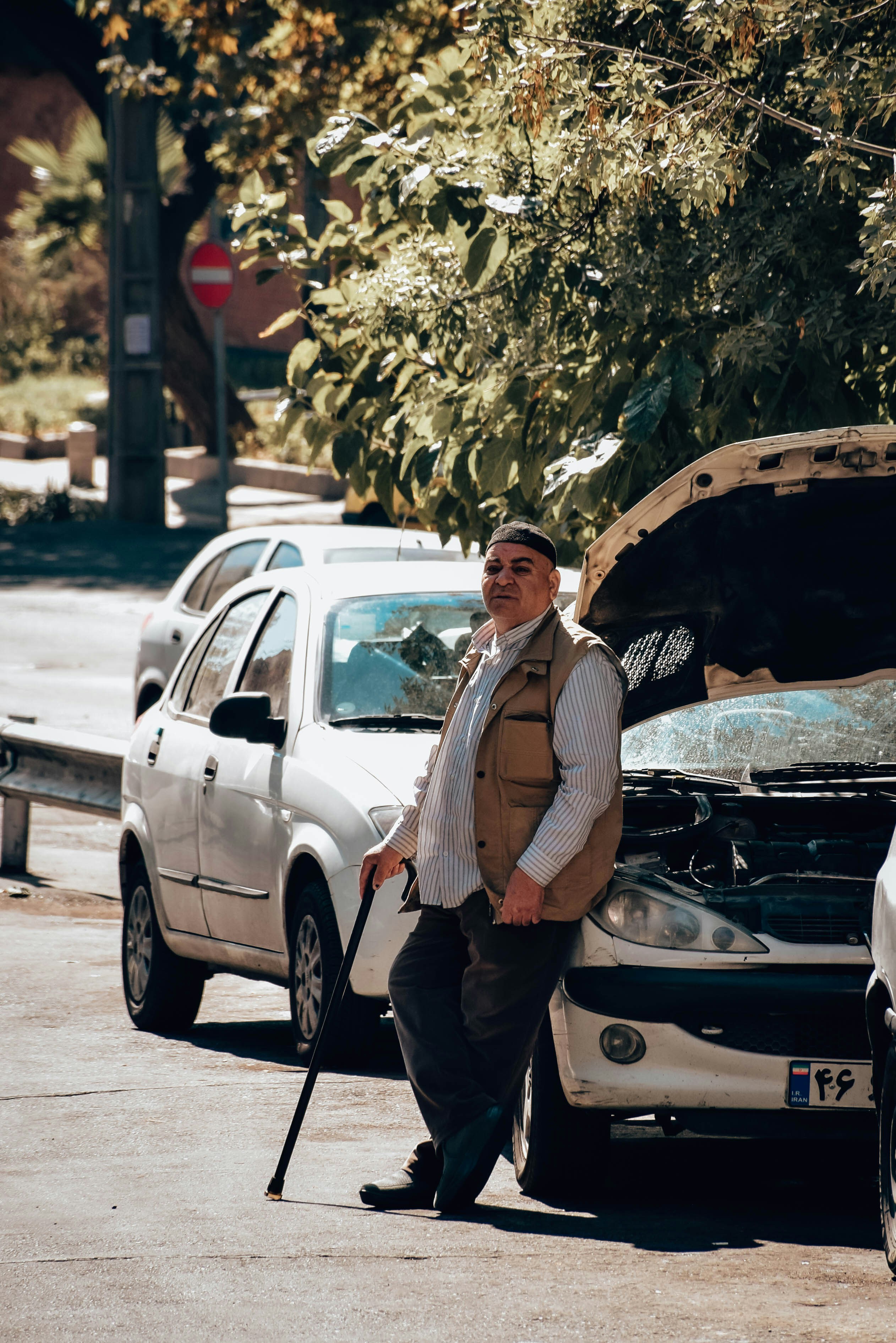 A man standing next to a parked car