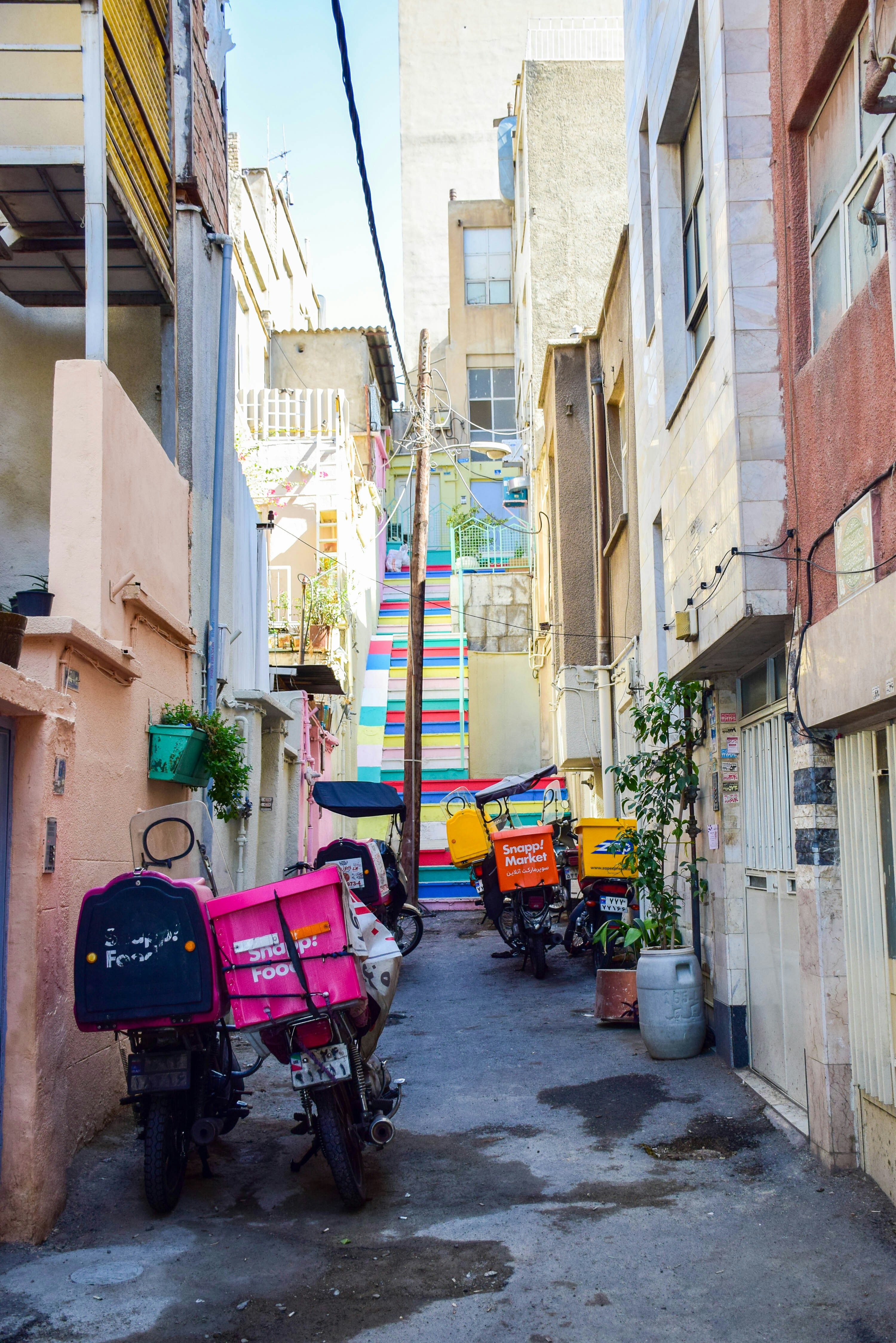 A narrow alleyway with parked mopeds and buildings