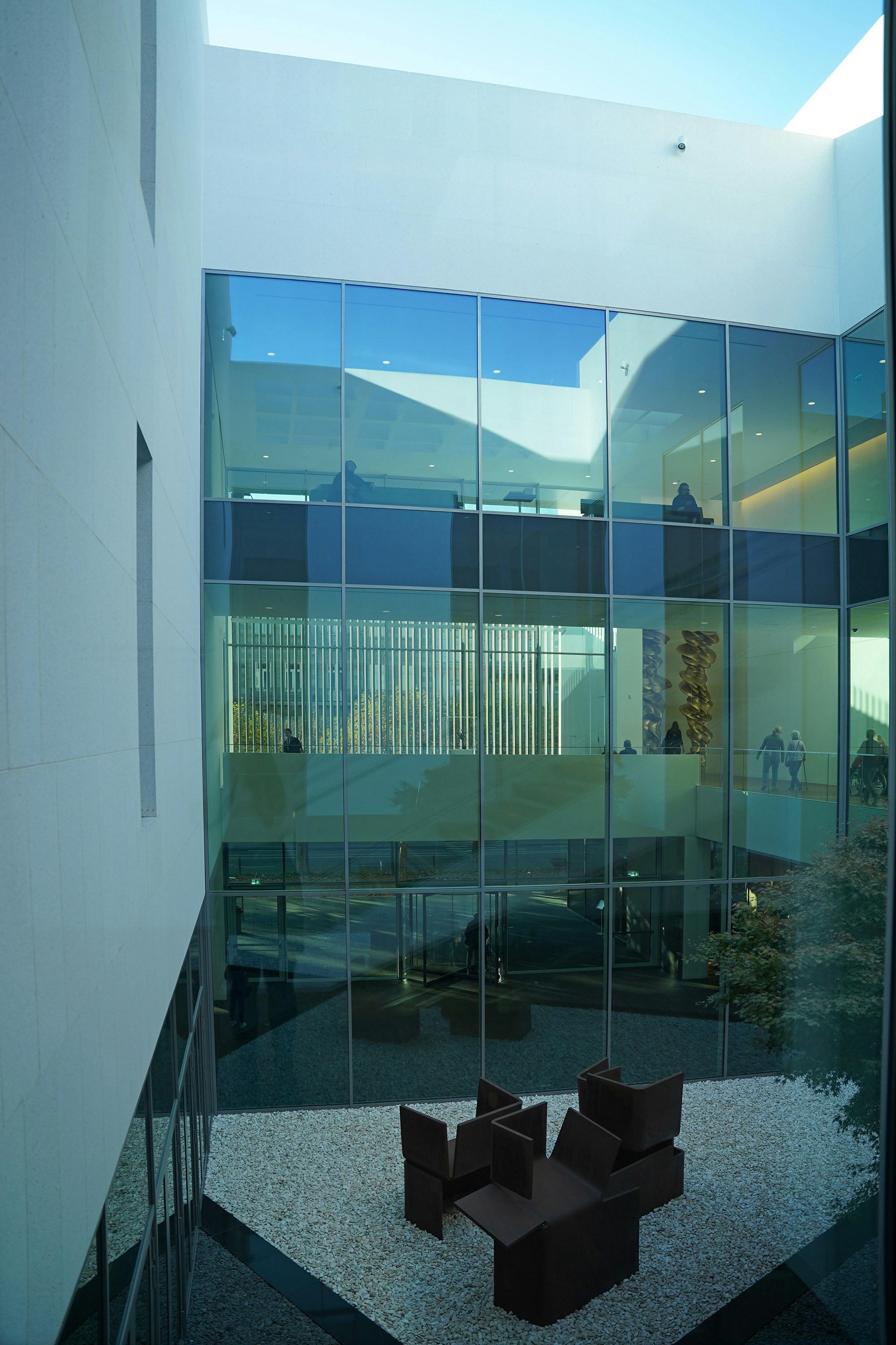 A room with chairs and a table in front of a glass wall
