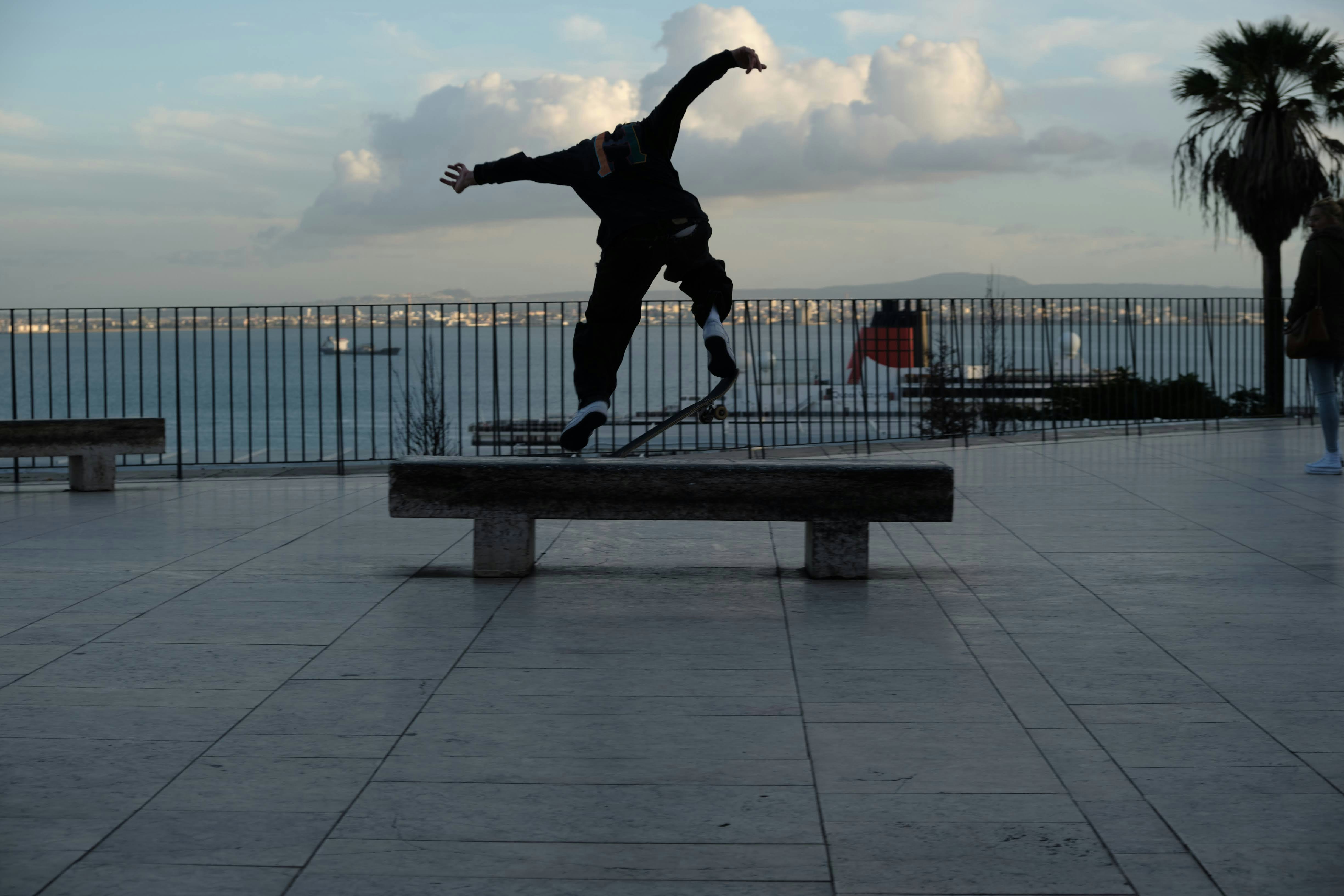 A skateboarder is doing a trick on a bench