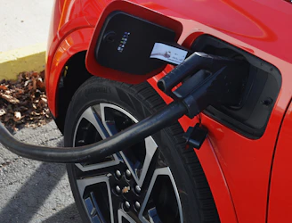 A red car with a charger hooked up to it