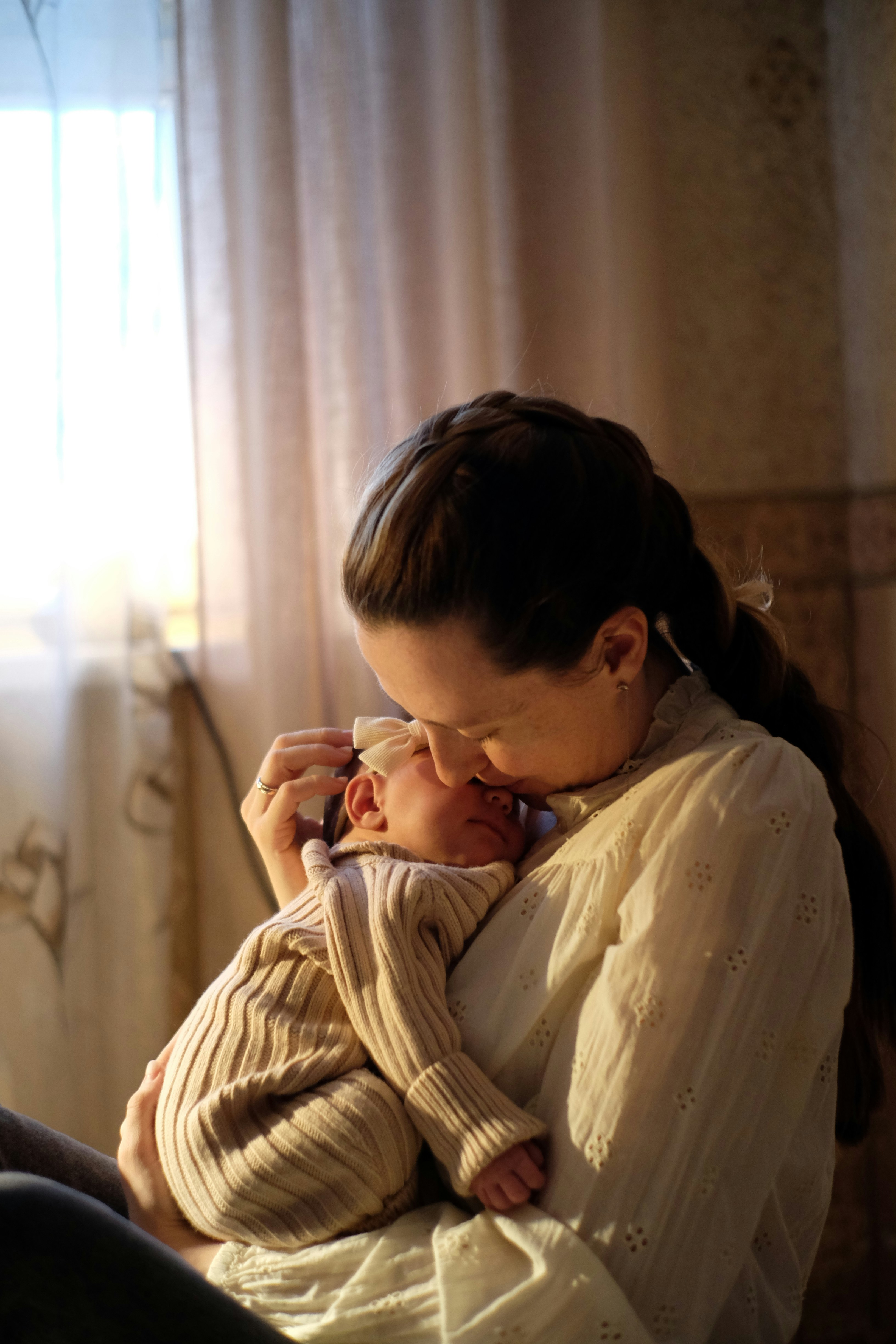 Mama tuląca dziecko w ciepłym, spokojnym świetle