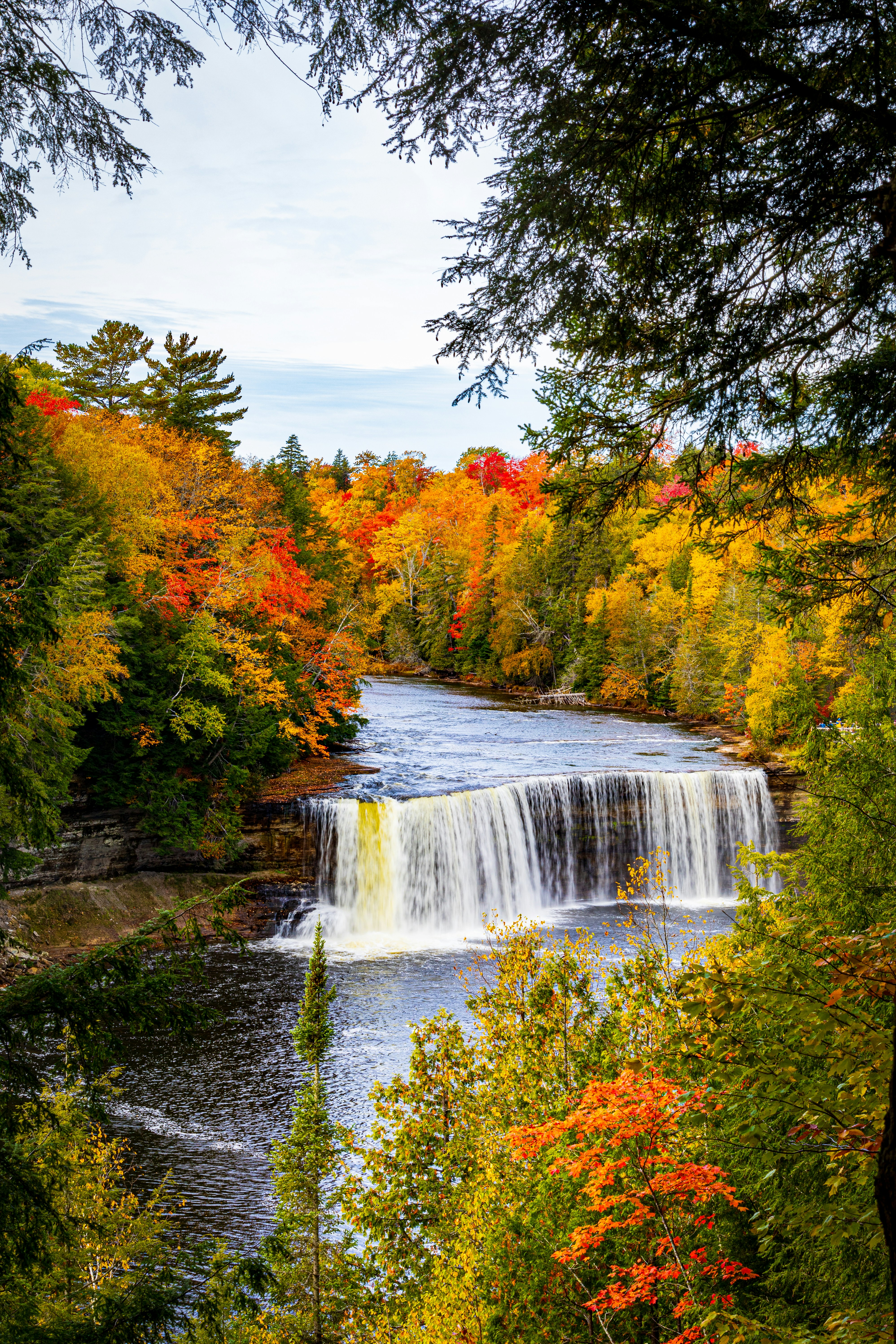 A waterfall surrounded by trees in the fall